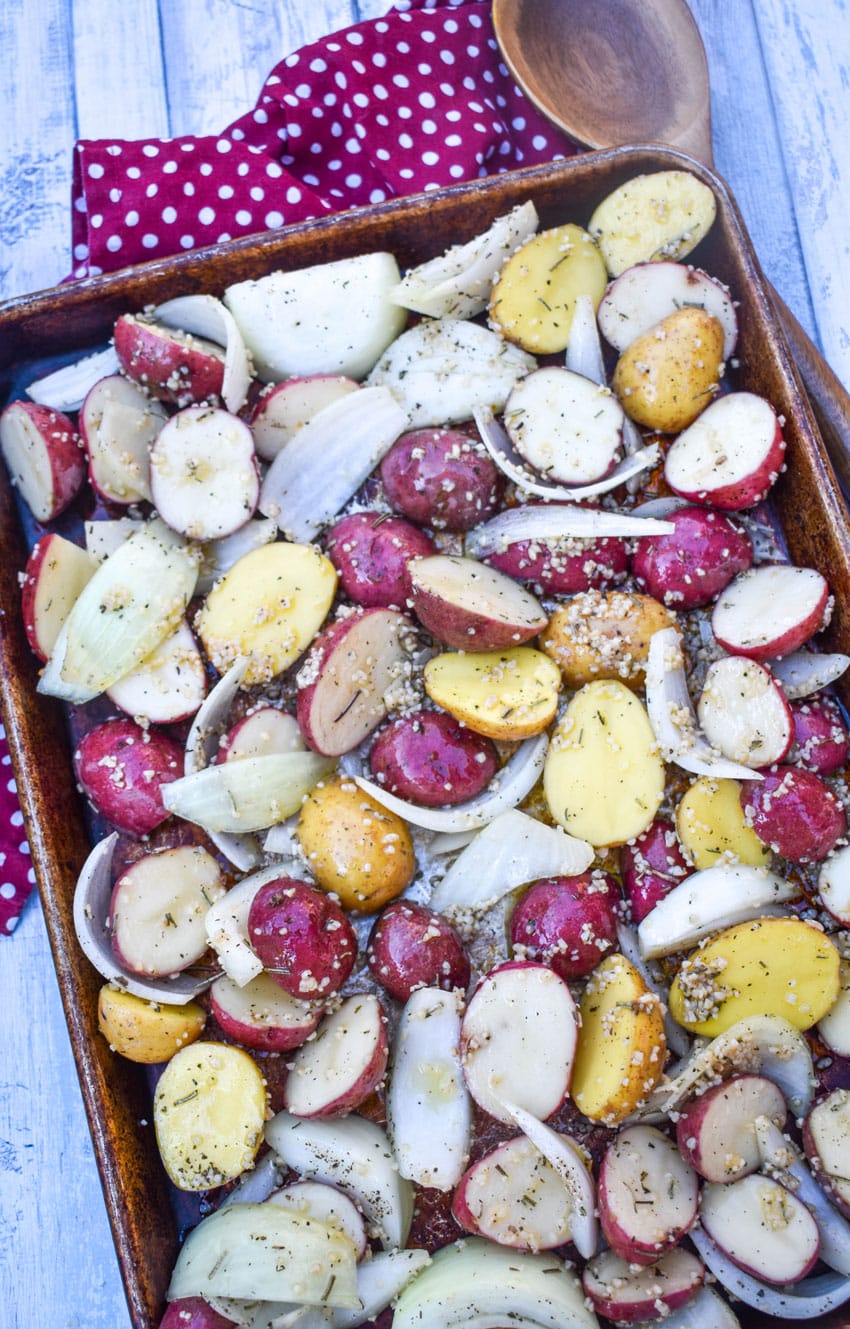 prepared chicken and seasoned vegetables on a metal sheet pan