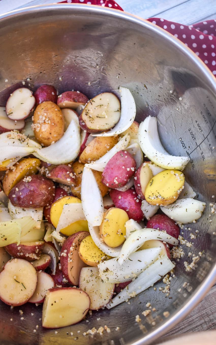 oil coated chopped vegetables in a metal mixing bowl