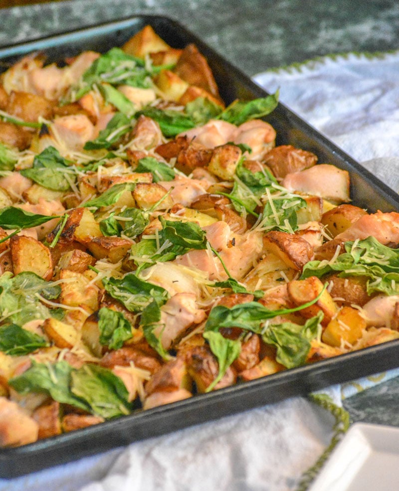 Roasted Chicken and Vegetable Sheet Pan Supper on top of a white dish towel with a green back ground