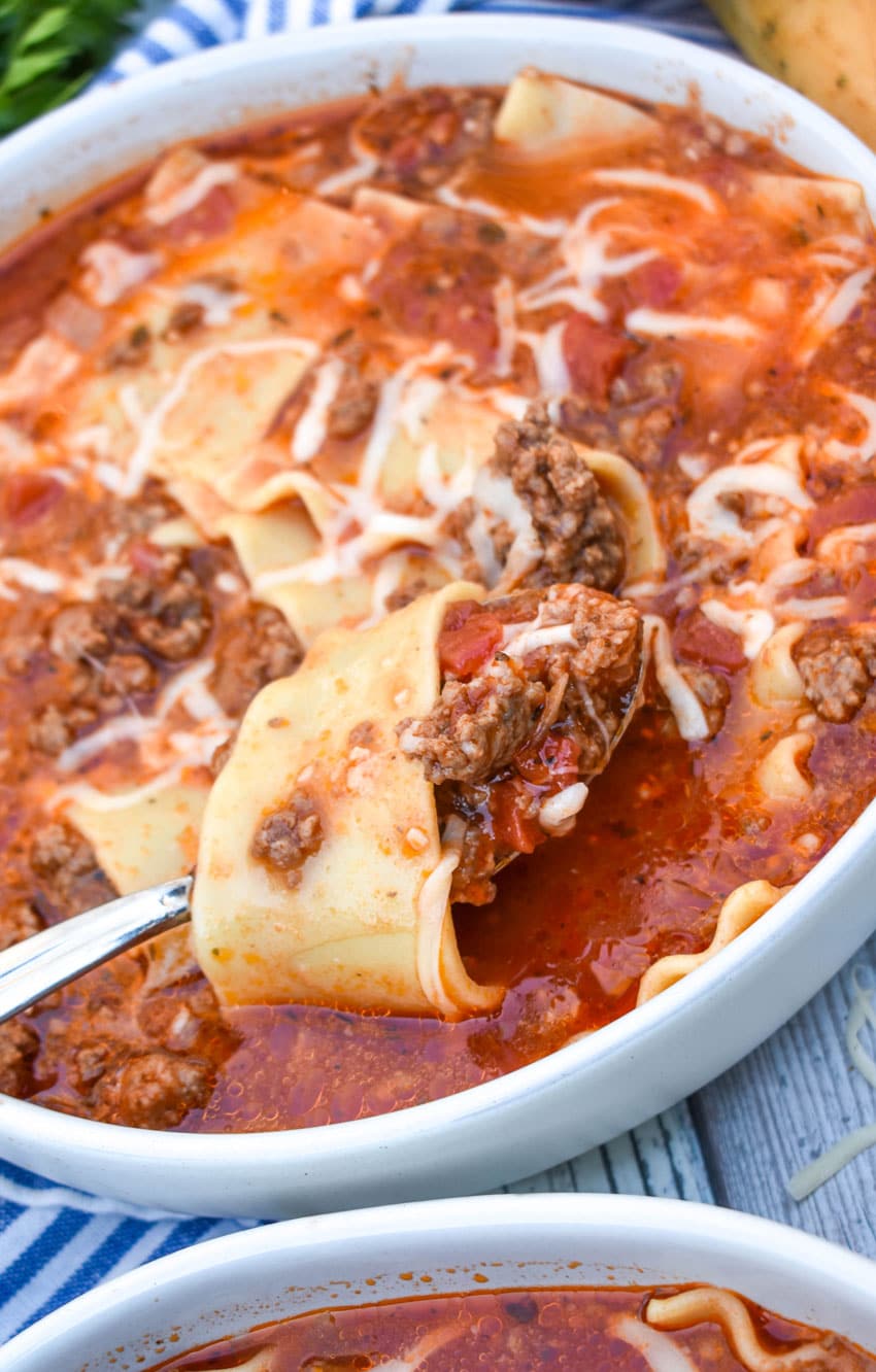 a silver spoon holding up a scoop of lasagna soup