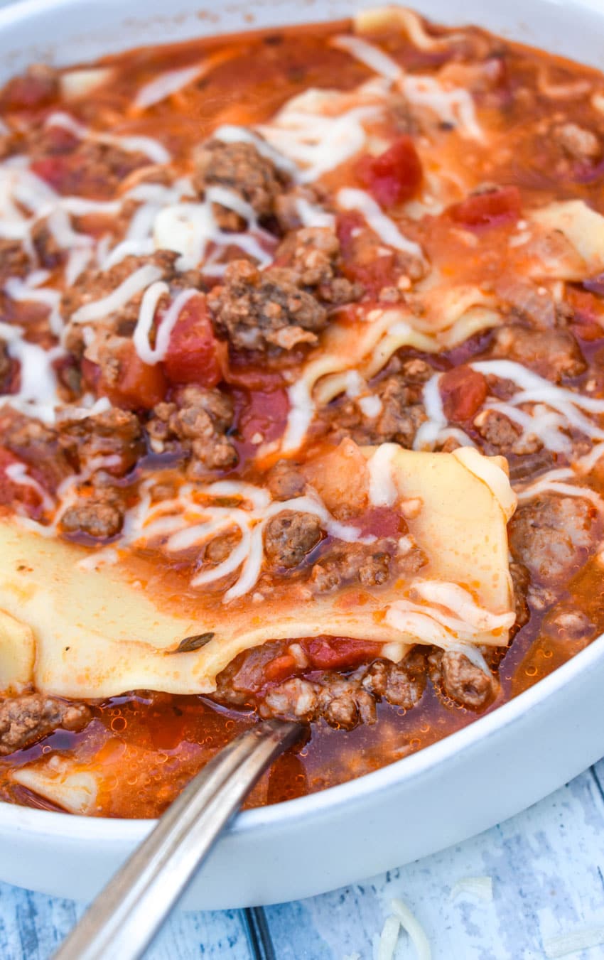 a silver spoon digging into a bowl of lasagna soup