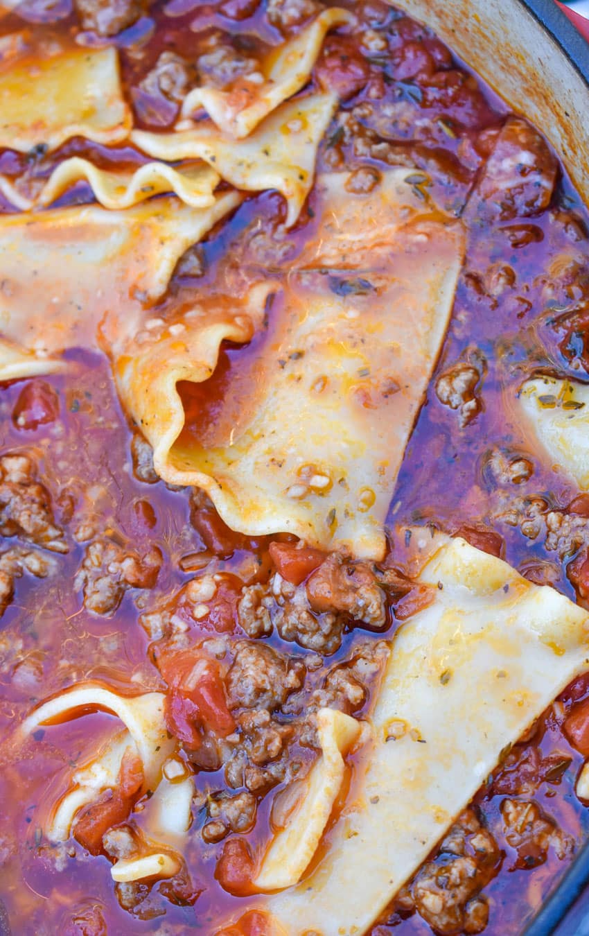 a close up of lasagna soup in a cast iron pot