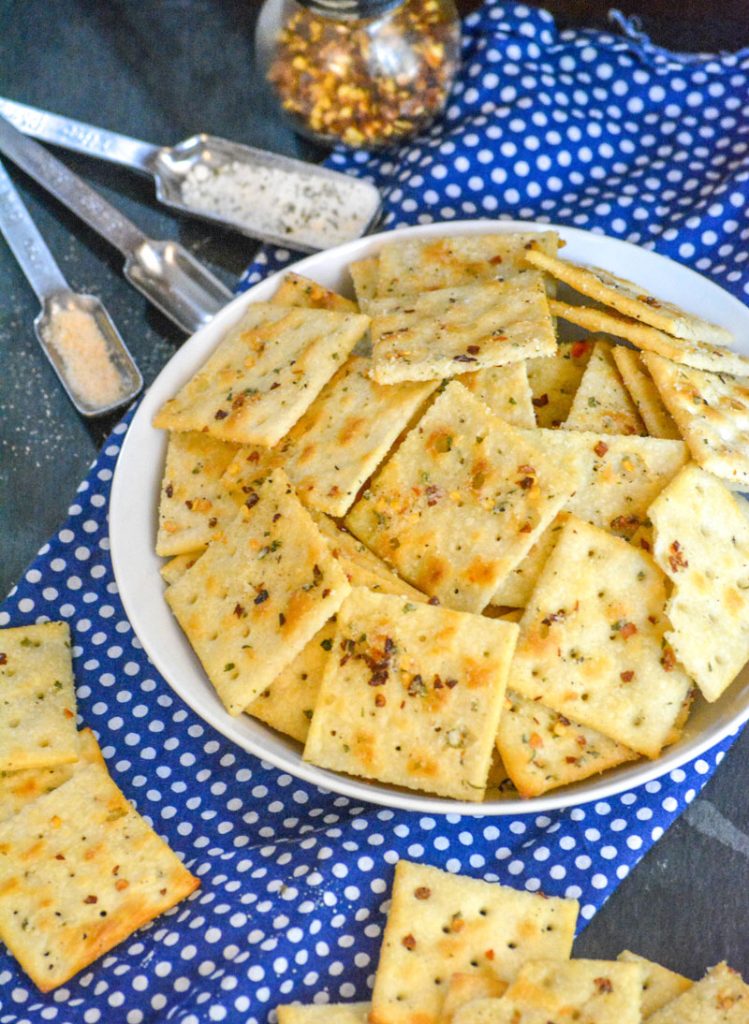 Alabama Fire Crackers in a white bowl on a white polka dotted blue cloth background with various spices in the background