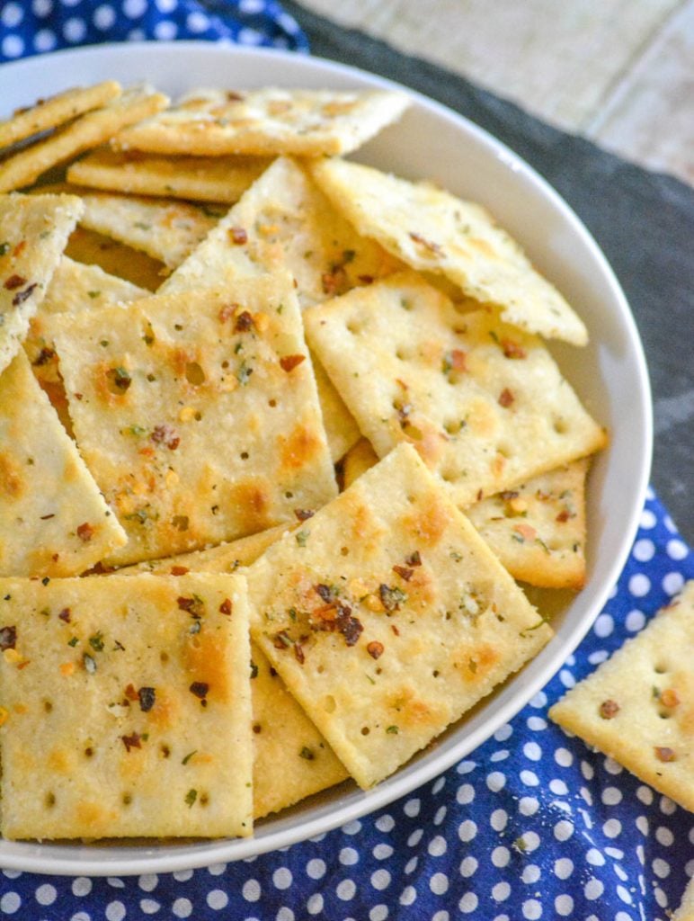 Spicy Ranch Seasoned Saltine Crackers in a white bowl on a white polka dotted blue cloth