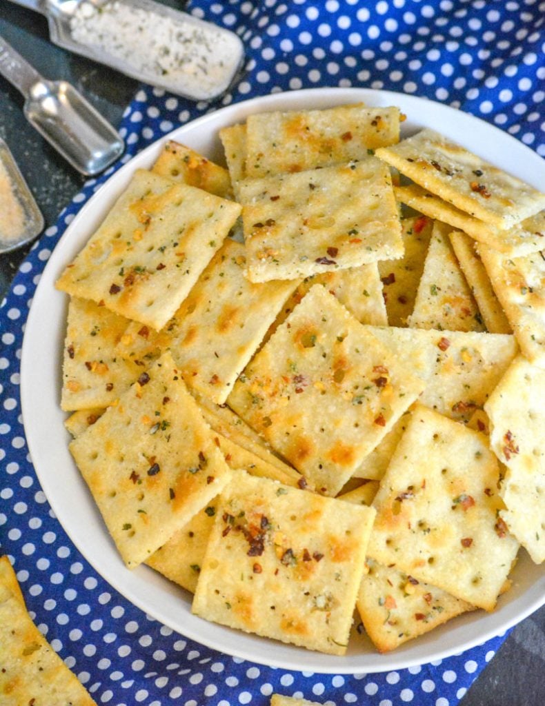 Alabama Fire Crackers in a white bowl on a white polka dotted blue cloth background with various spices in the background