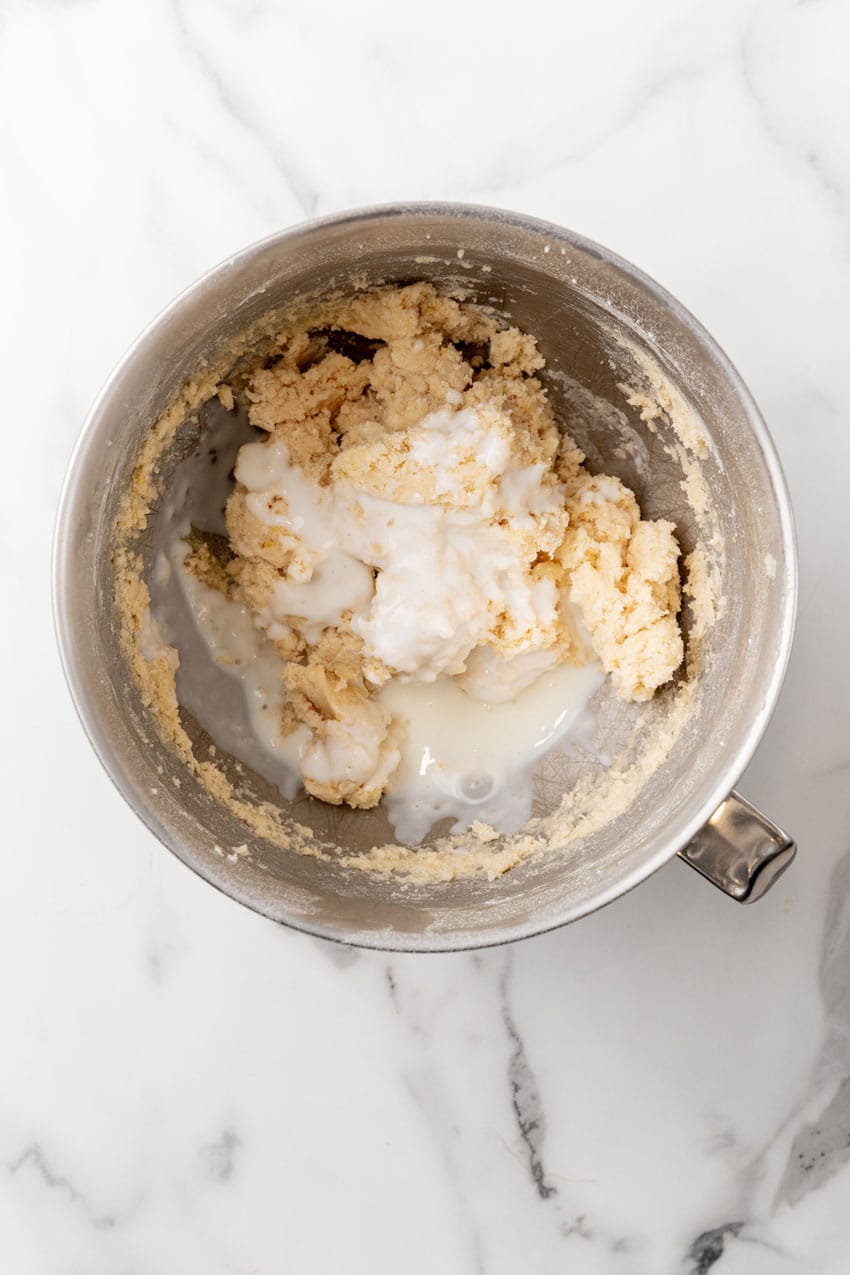 cake batter being mixed in a metal mixing bowl