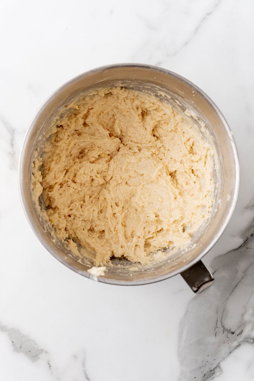 cake batter being mixed in a metal mixing bowl