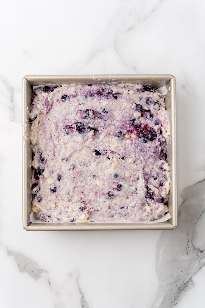 buttermilk blueberry breakfast cake batter in a square metal baking dish