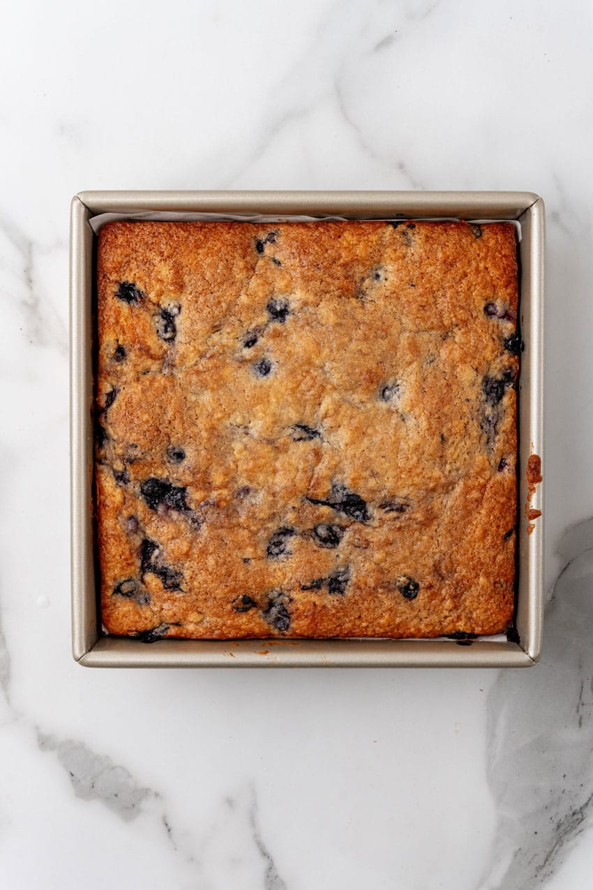 a baked buttermilk blueberry breakfast cake in a square metal baking dish