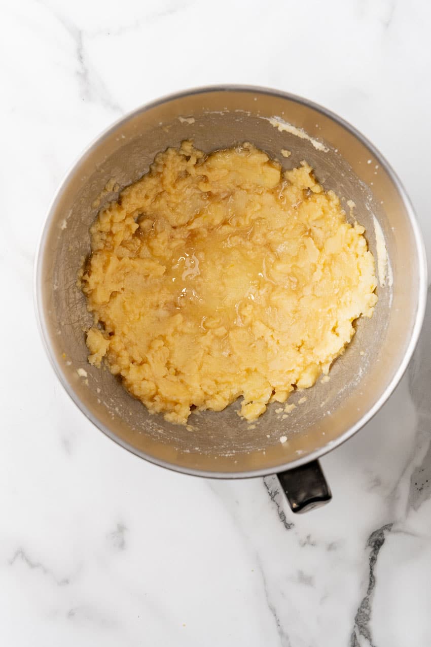 cake batter being mixed in a metal mixing bowl