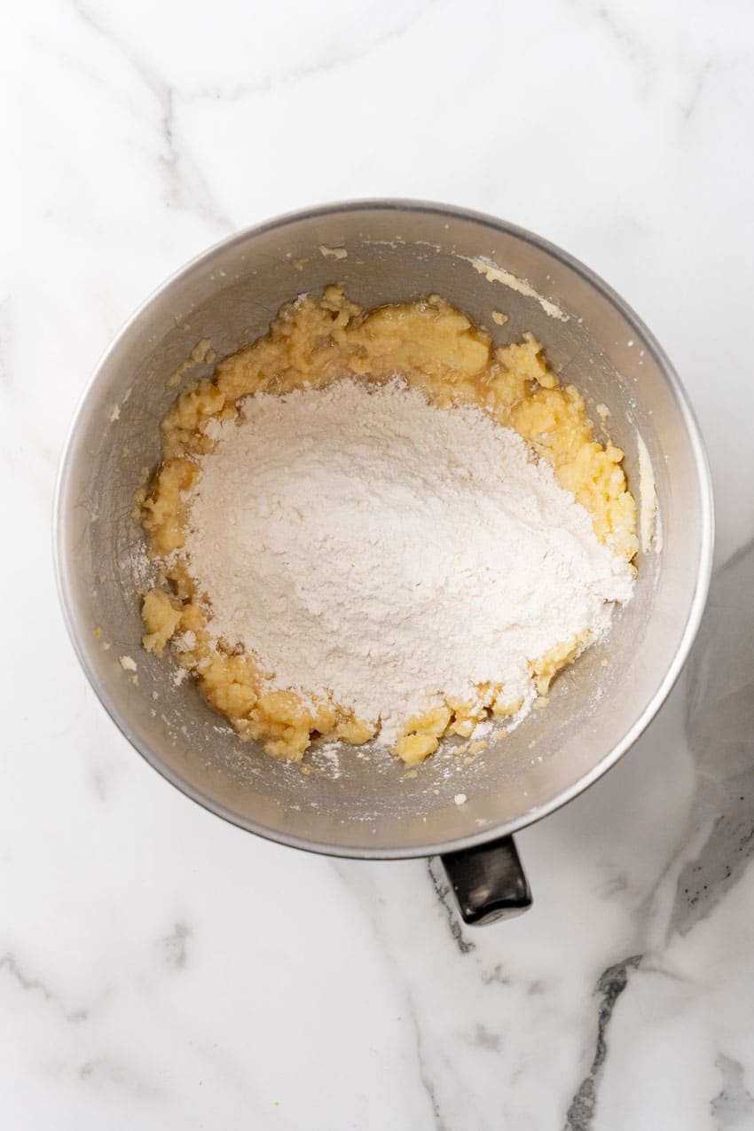 cake batter being mixed in a metal mixing bowl