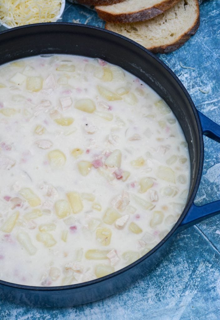 chicken cordon bleu soup in a large enameled cast iron dutch oven on a blue background