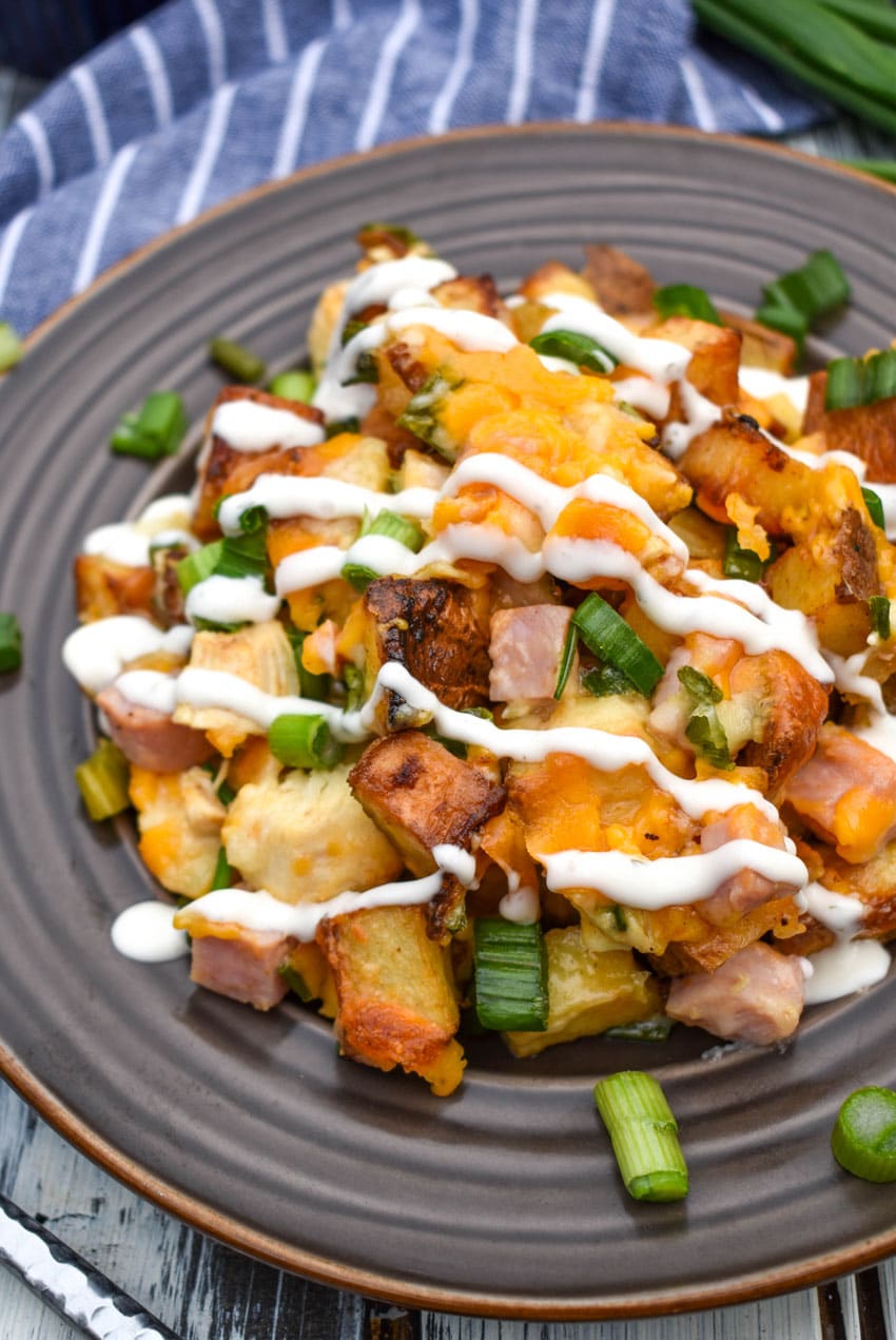 Loaded baked potato  chicken casserole drizzled with ranch dressing on a small brown plate