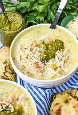 chicken pesto soup topped with a dollop of basil pesto sauce in a white bowl