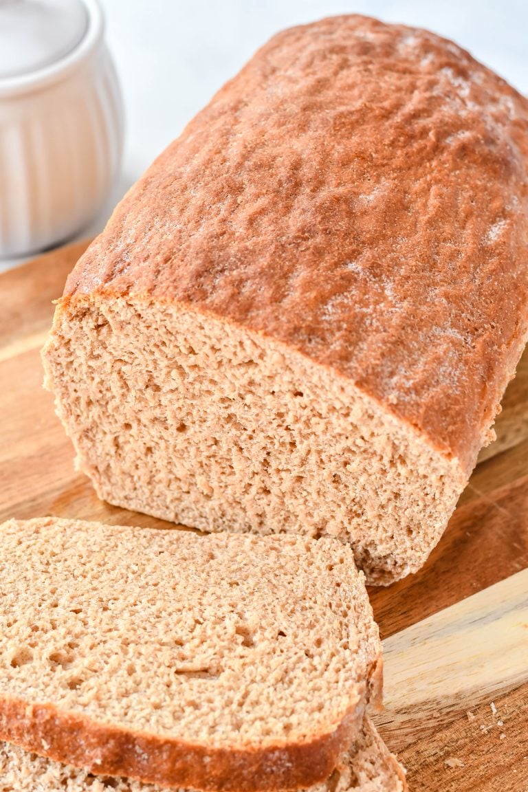 sliced honey wheat sandwich bread on a wooden cutting board