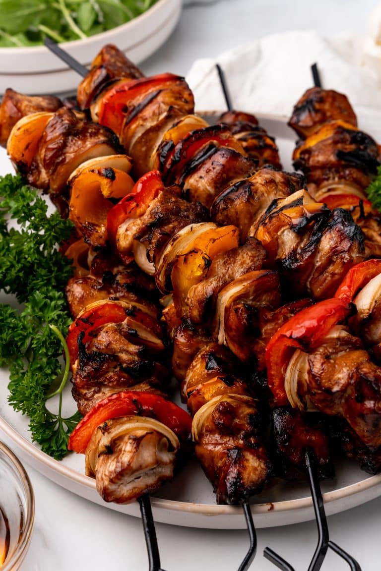 honey garlic chicken kabobs on a lettuce lined white plate