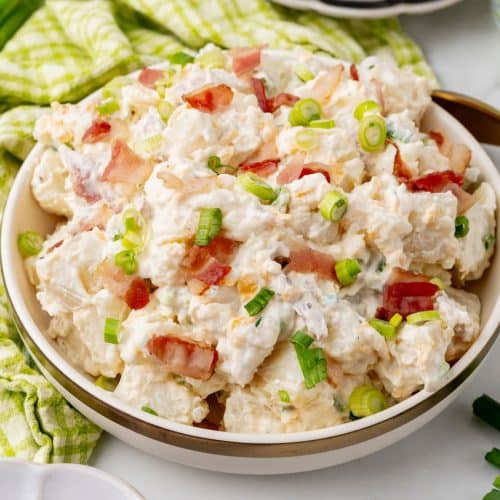 LOADED BAKED POTATO SALAD IN A WHITE SERVING BOWL