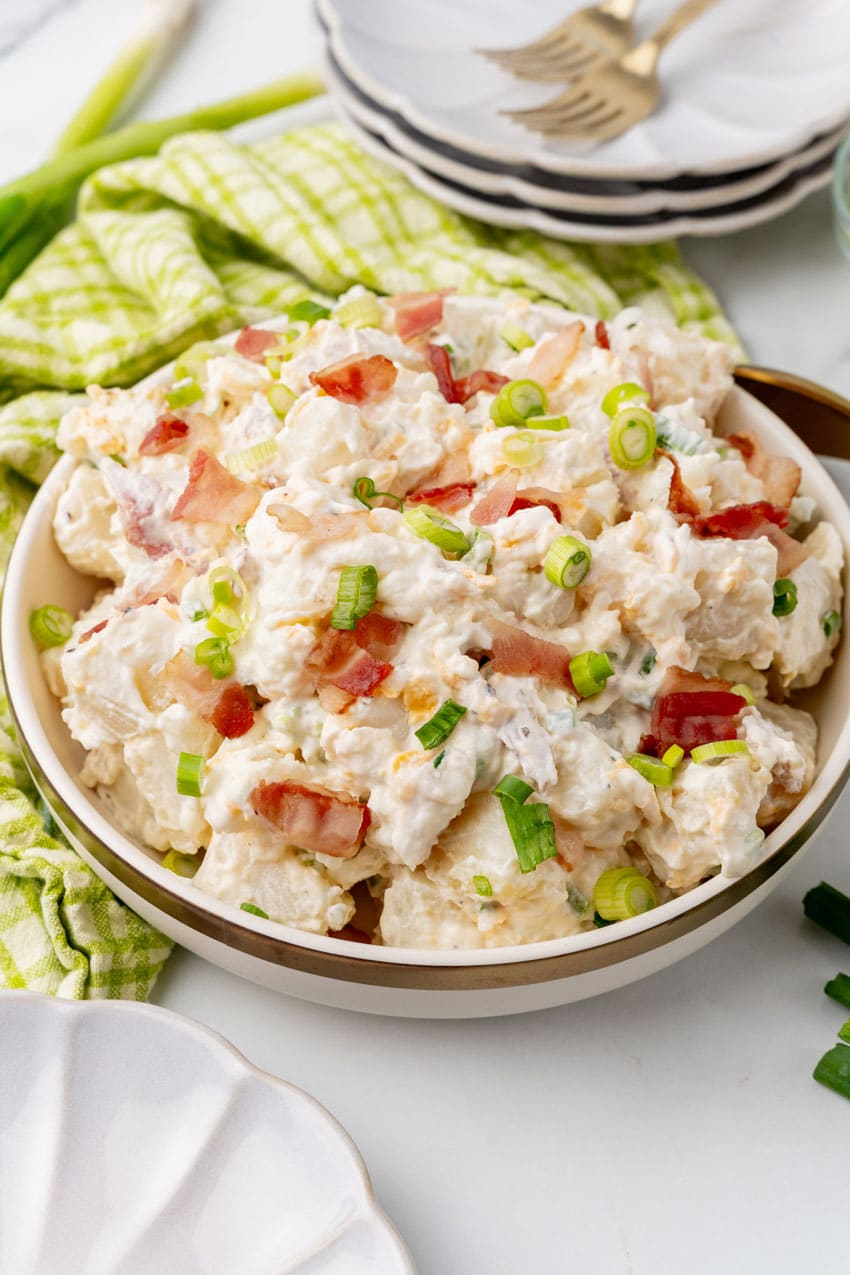LOADED BAKED POTATO SALAD IN A WHITE SERVING BOWL