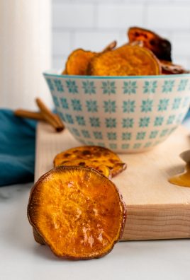 sweet potato chips resting on a wooden cutting board