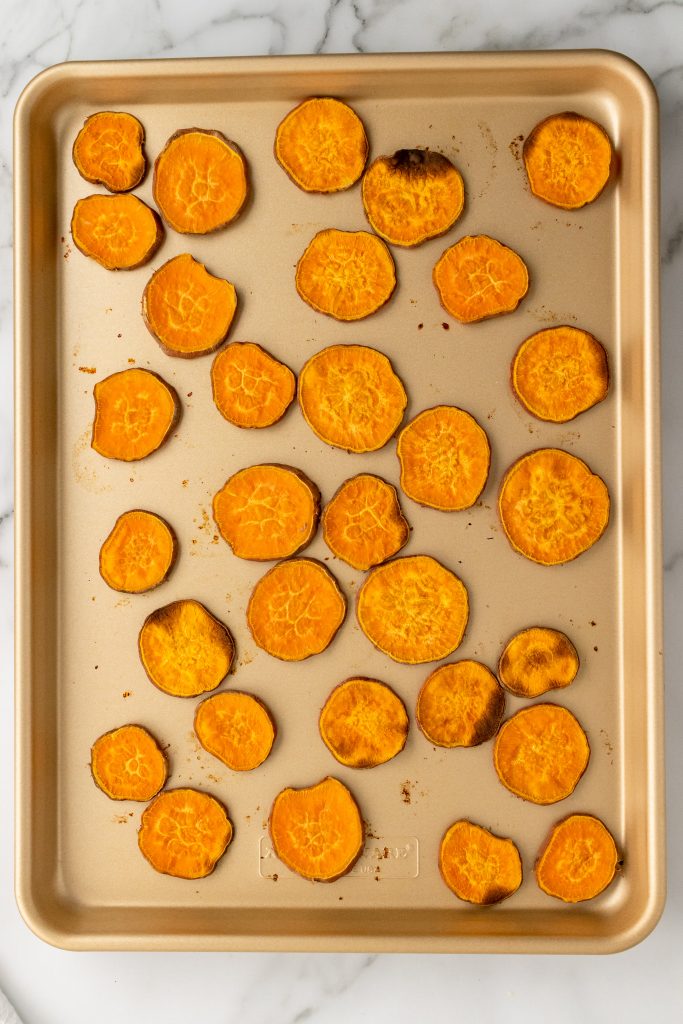baked sweet potato chips on a rimmed metal baking sheet