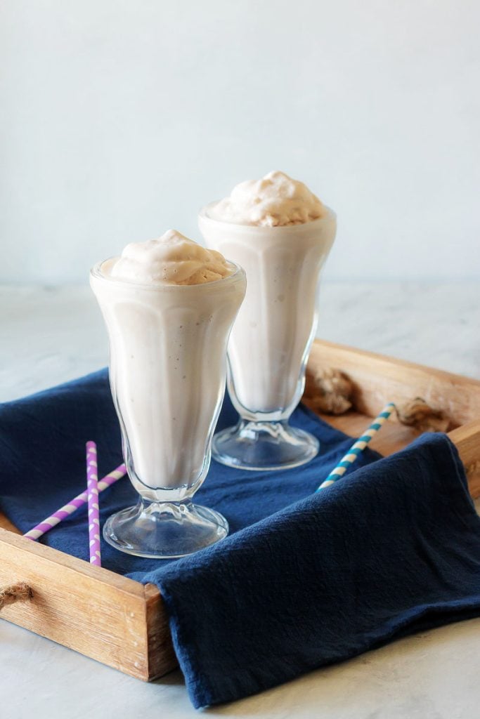 Copy Cat Wendy's Frosty in two high milkshake glasses in a wooden serving tray with a dark blue cloth napkin