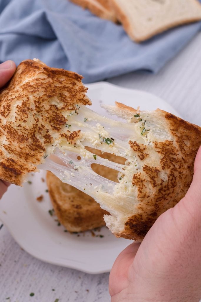 a white pizza grilled cheese sandwich being pulled apart