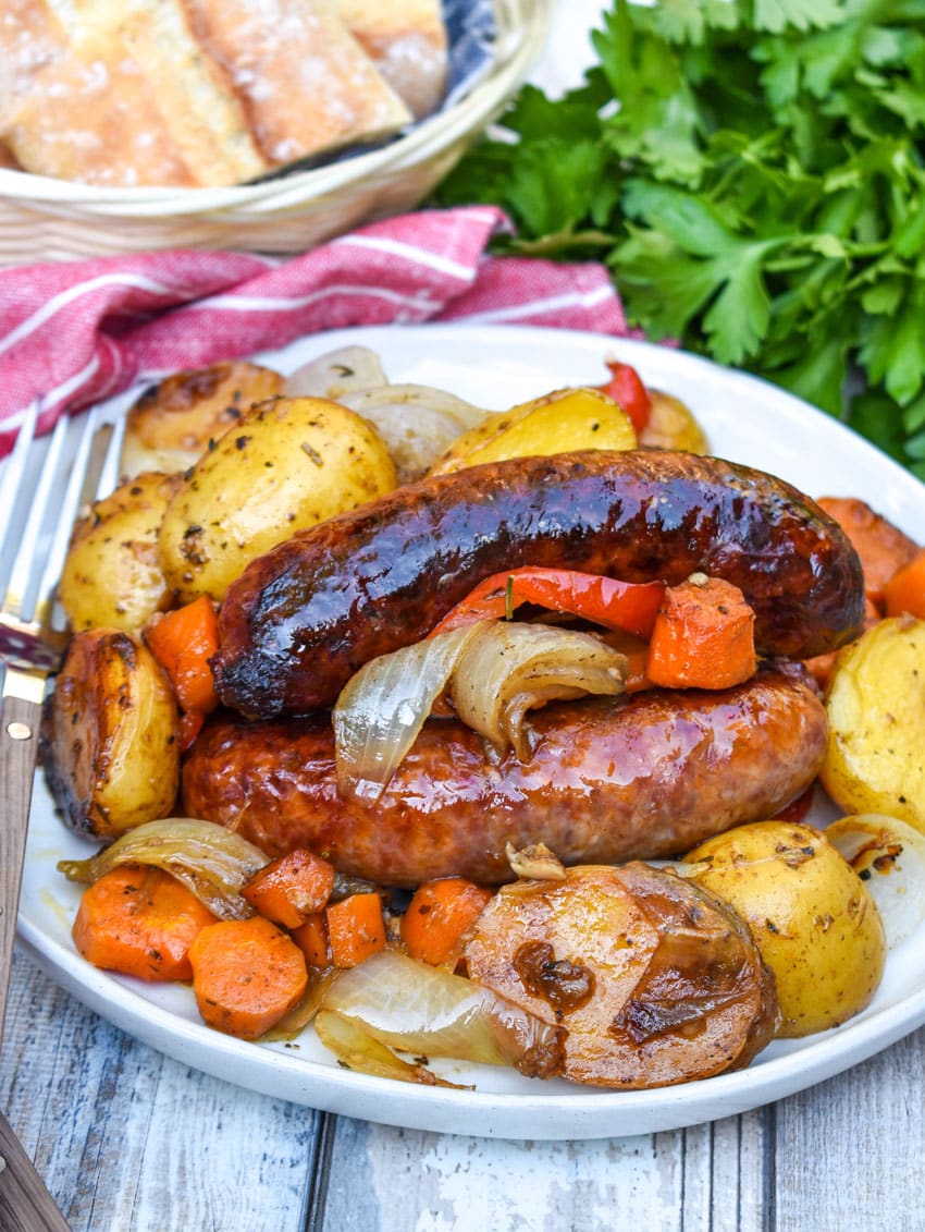 baked Italian sausage and vegetables on a white plate
