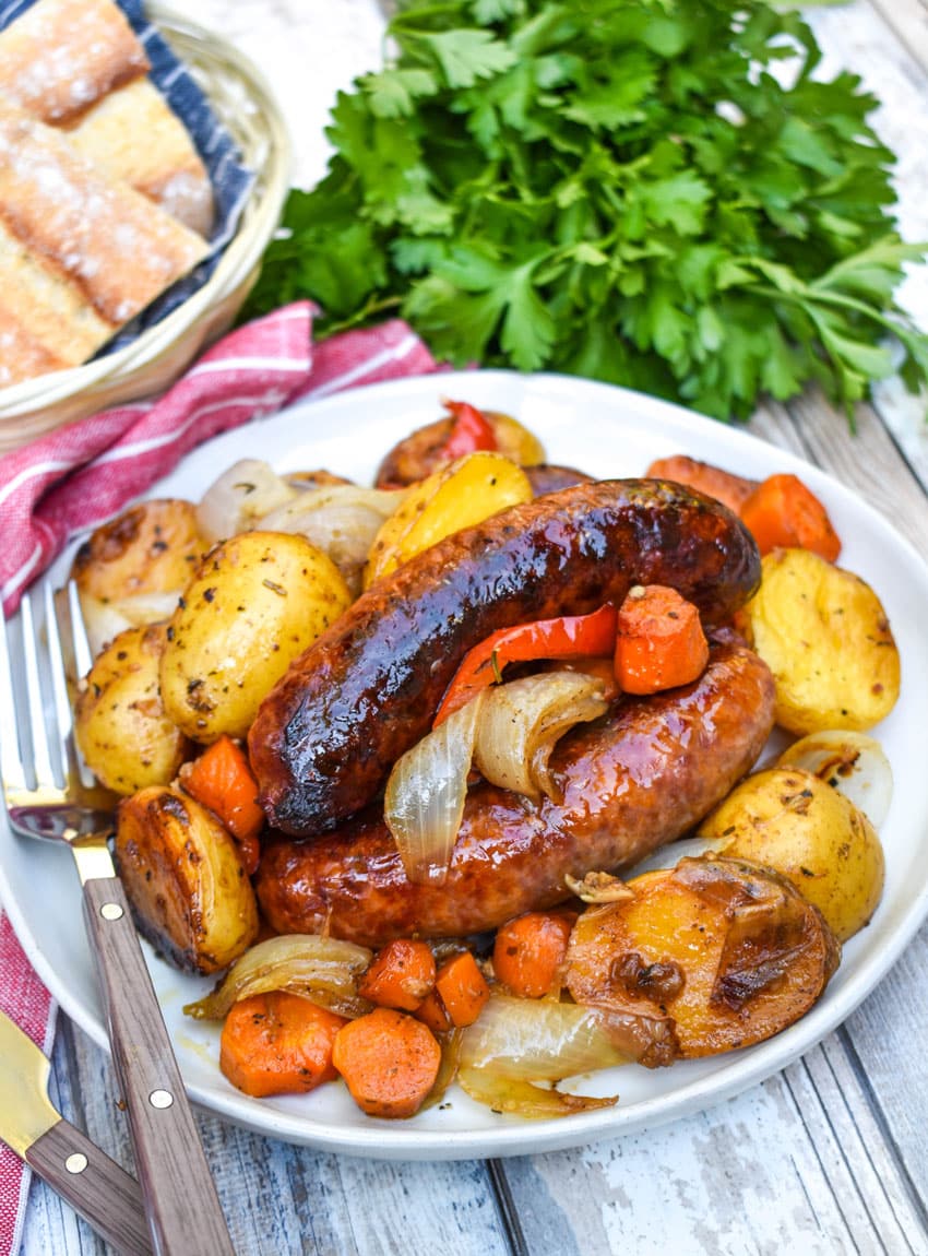 baked Italian sausage and potatoes on a white plate