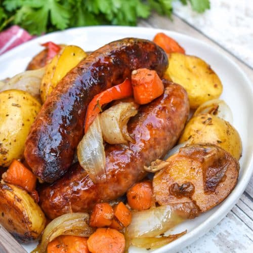 baked Italian sausage and vegetables on a white plate