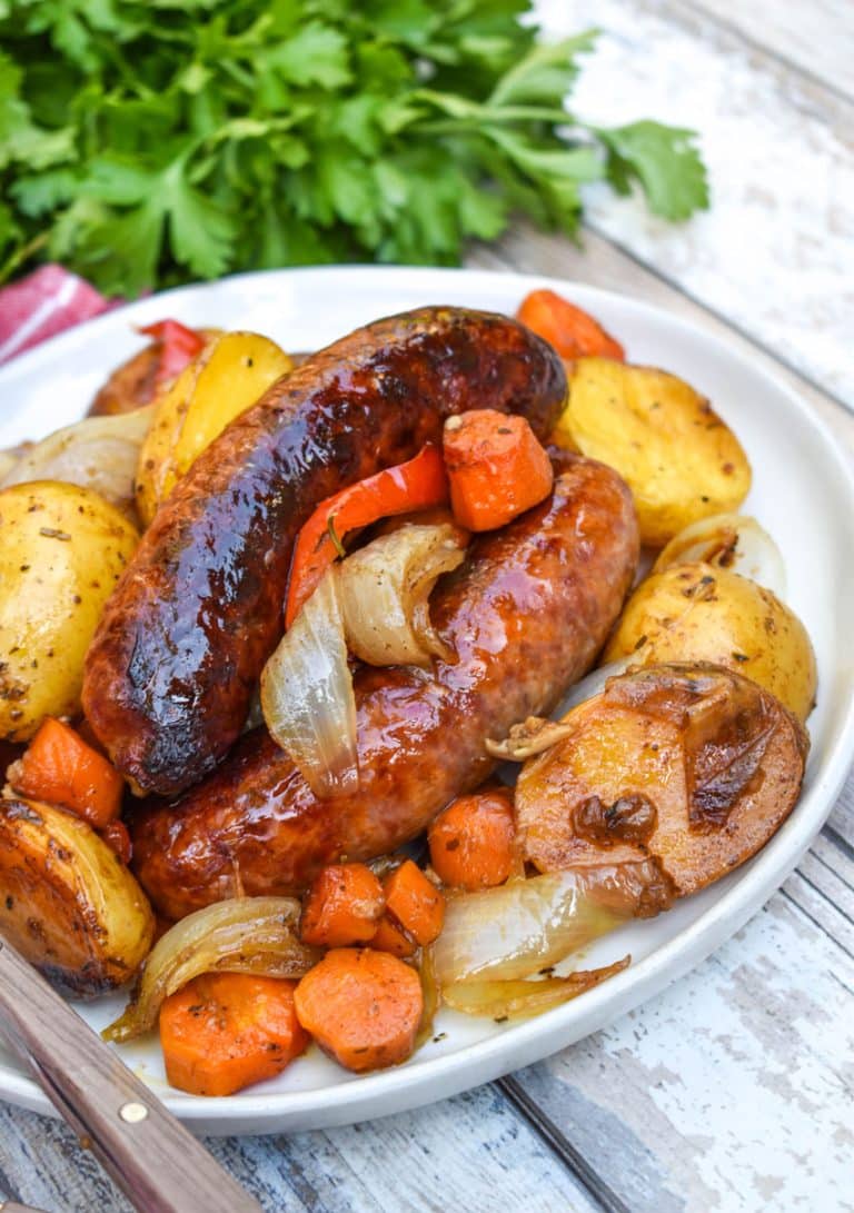 baked Italian sausage and vegetables on a white plate