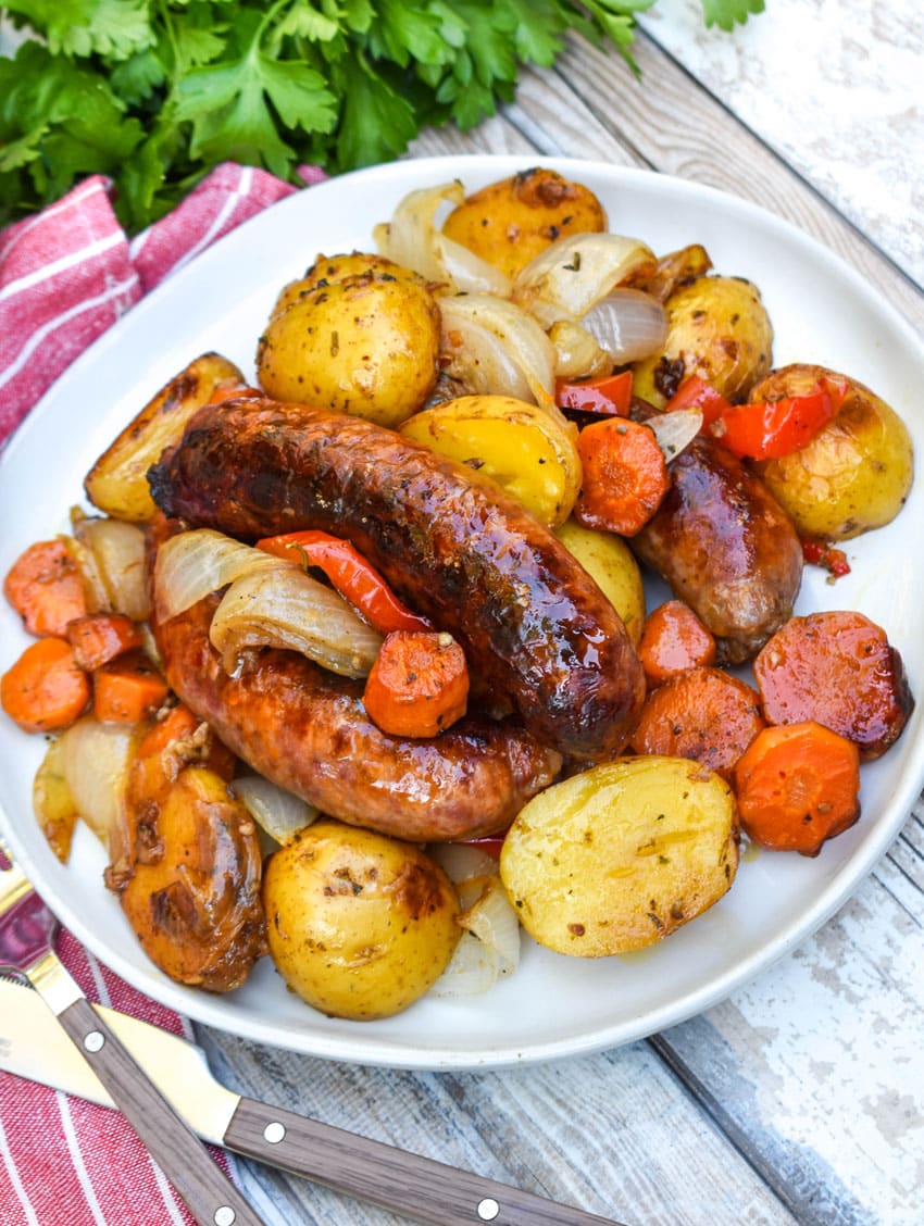 baked Italian sausage and potatoes on a white plate