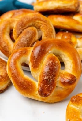 salty and sweet homemade pretzels stacked on a white plate