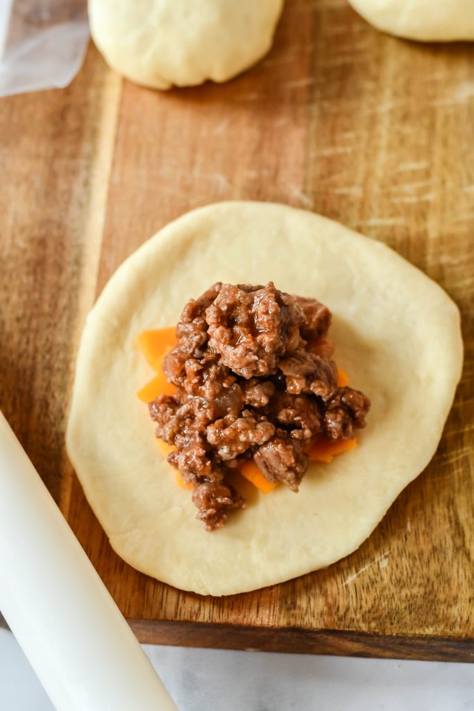 cheeseburger bun dough topped with cheese and saucy ground beef mixture