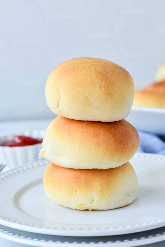 three cheeseburger buns stacked on top of each other on a white plate