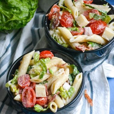 ranch blt pasta salad shown served in two small black bowls
