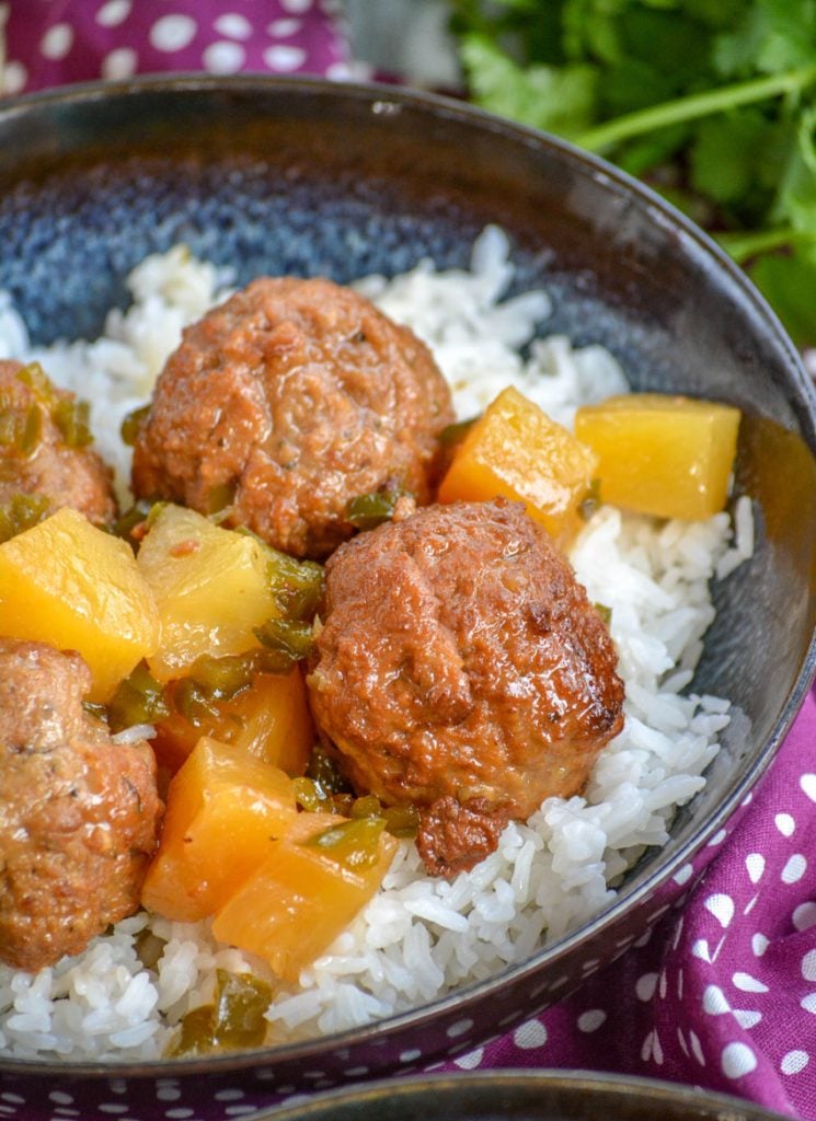 Crockpot Hawaiian Meatballs over a bed of rice in glazed bowl