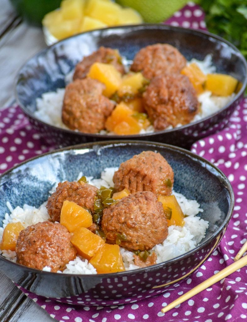 Crockpot Hawaiian Meatballs over a bed of rice in glazed bowls