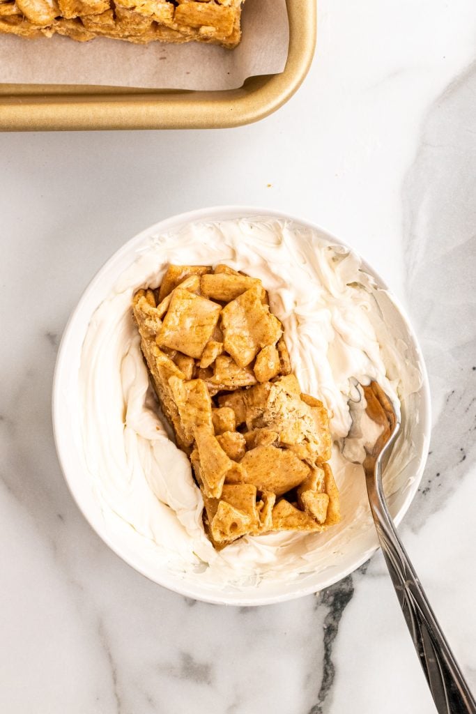 cinnamon toast crunch cereal bar sitting in a bowl of melted white chocolate