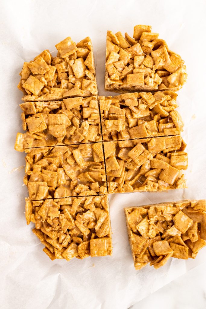 cinnamon toast crunch cereal bar slab on a sheet of crinkled white parchment paper with cut marks in it