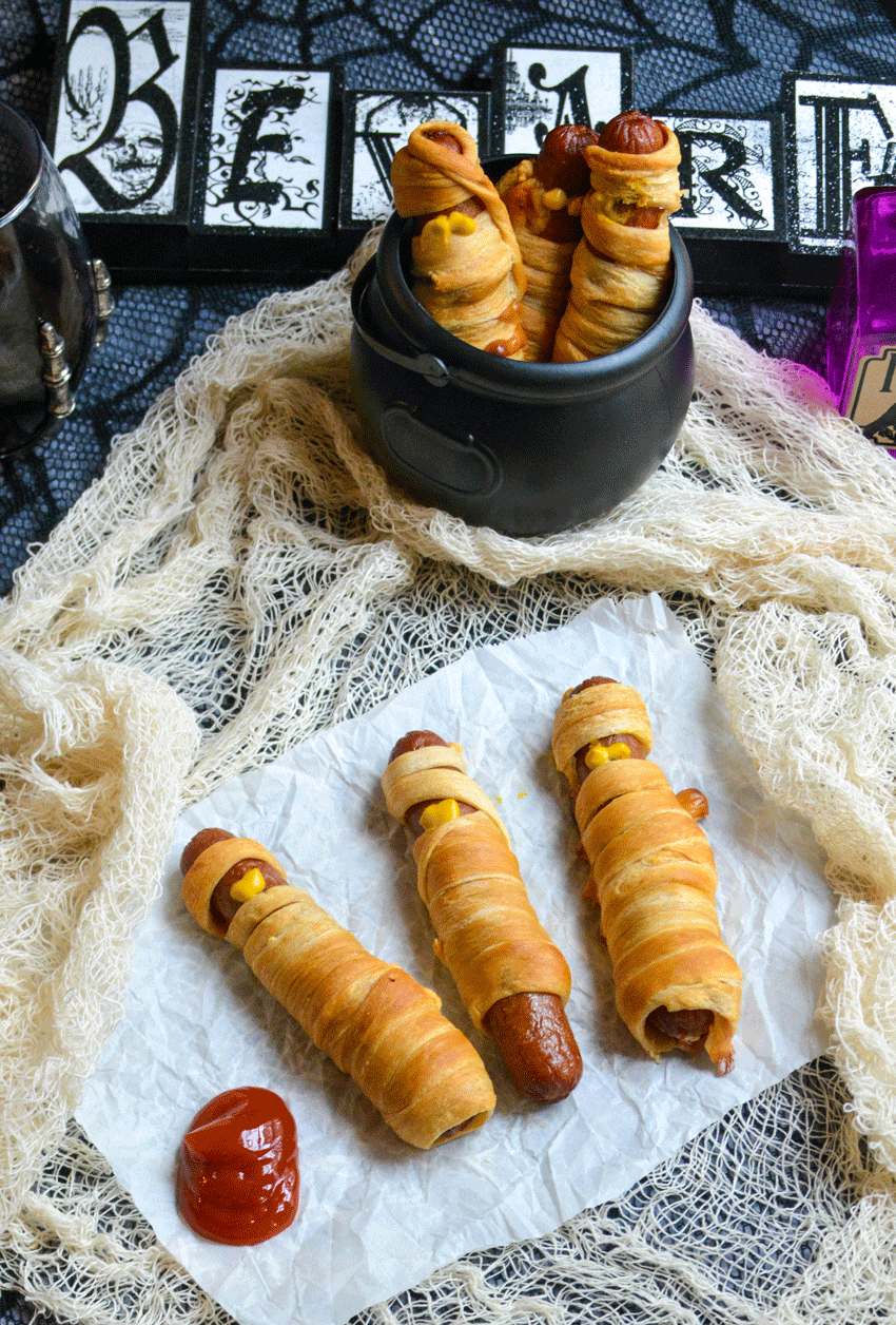 baked mummy dogs on a piece of white parchment paper