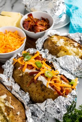 three crockpot baked potatoes arranged in a row and loaded with toppings