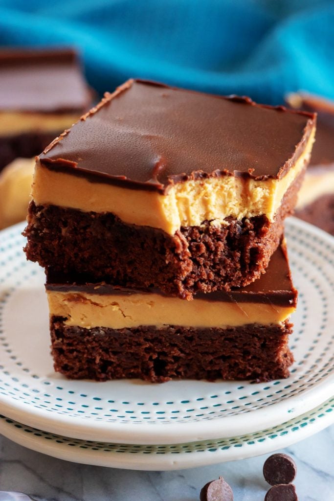 Buckeye Brownies stacked two high, with a forkful removed showing the layers of brownie peanut butter & chocolate ganache