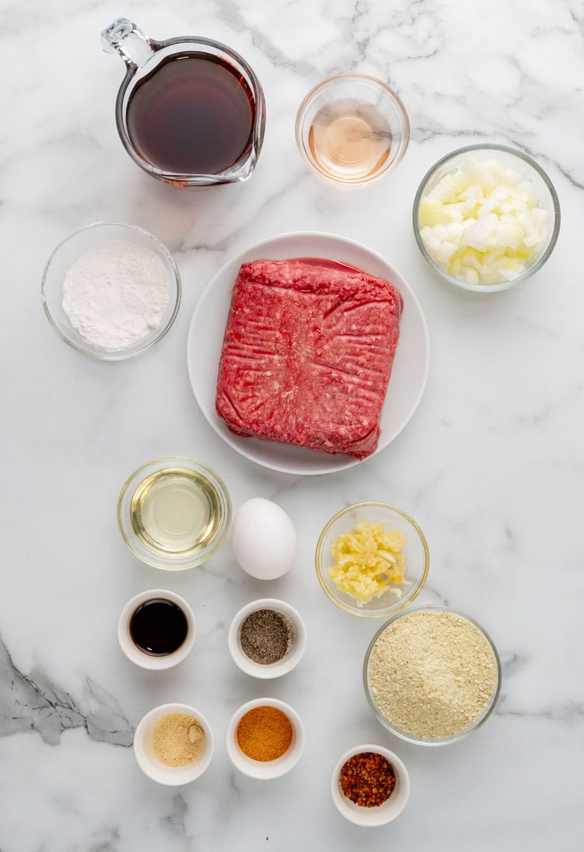 an overhead image showing the measured ingredients needed to make a batch of hamburger steaks with gravy and onions