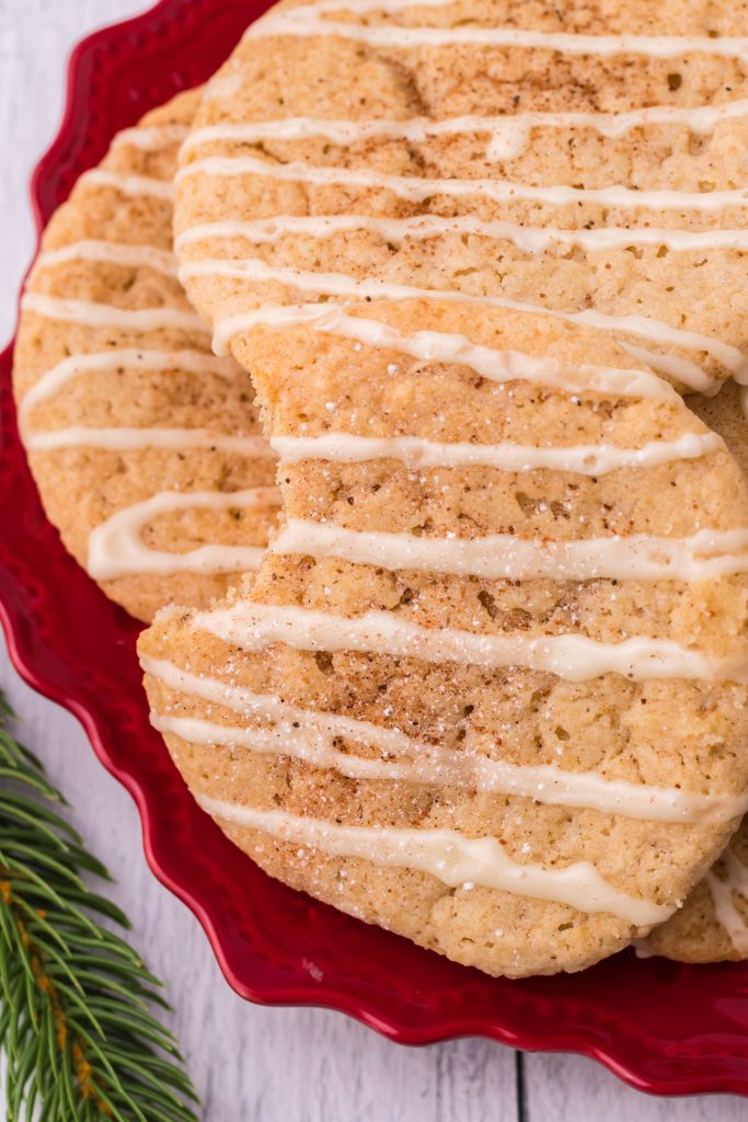 a bitten iced eggnog cookie on a red plate