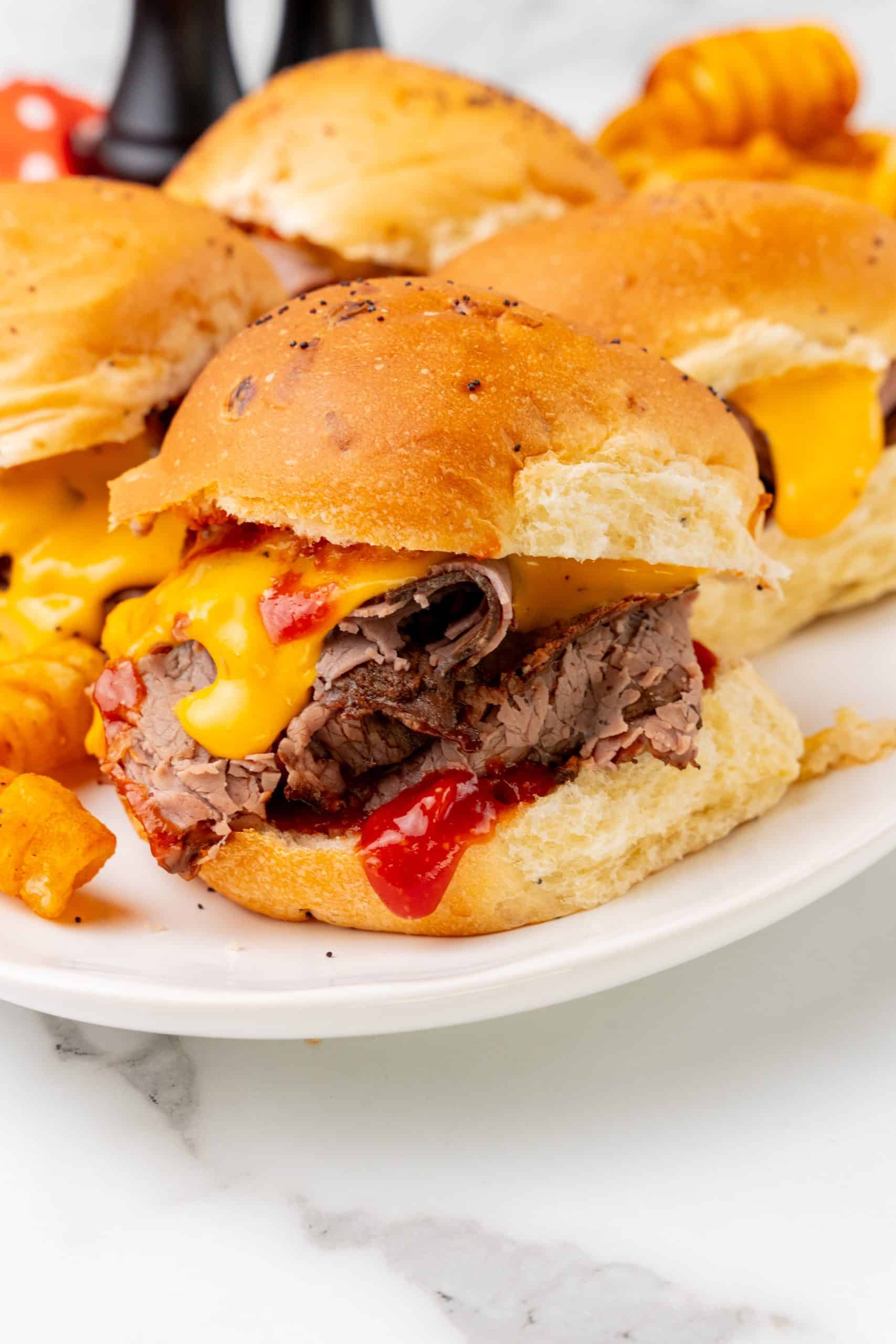 copycat arby's beef n' cheddars on white plates with curly fries on the side