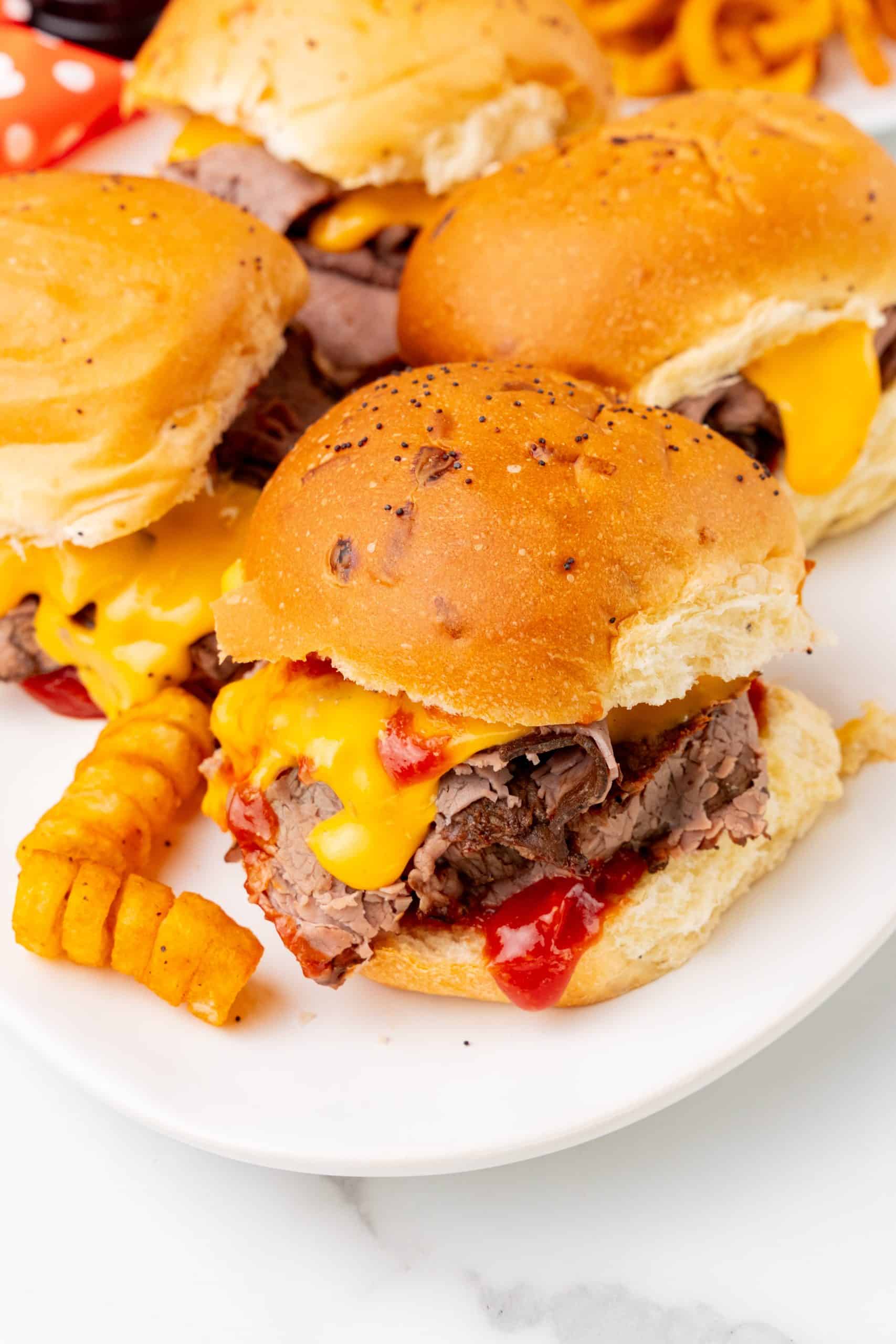 copycat arby's beef n' cheddars on white plates with curly fries on the side