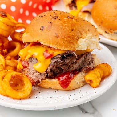 copycat arby's beef n' cheddars on white plates with curly fries on the side