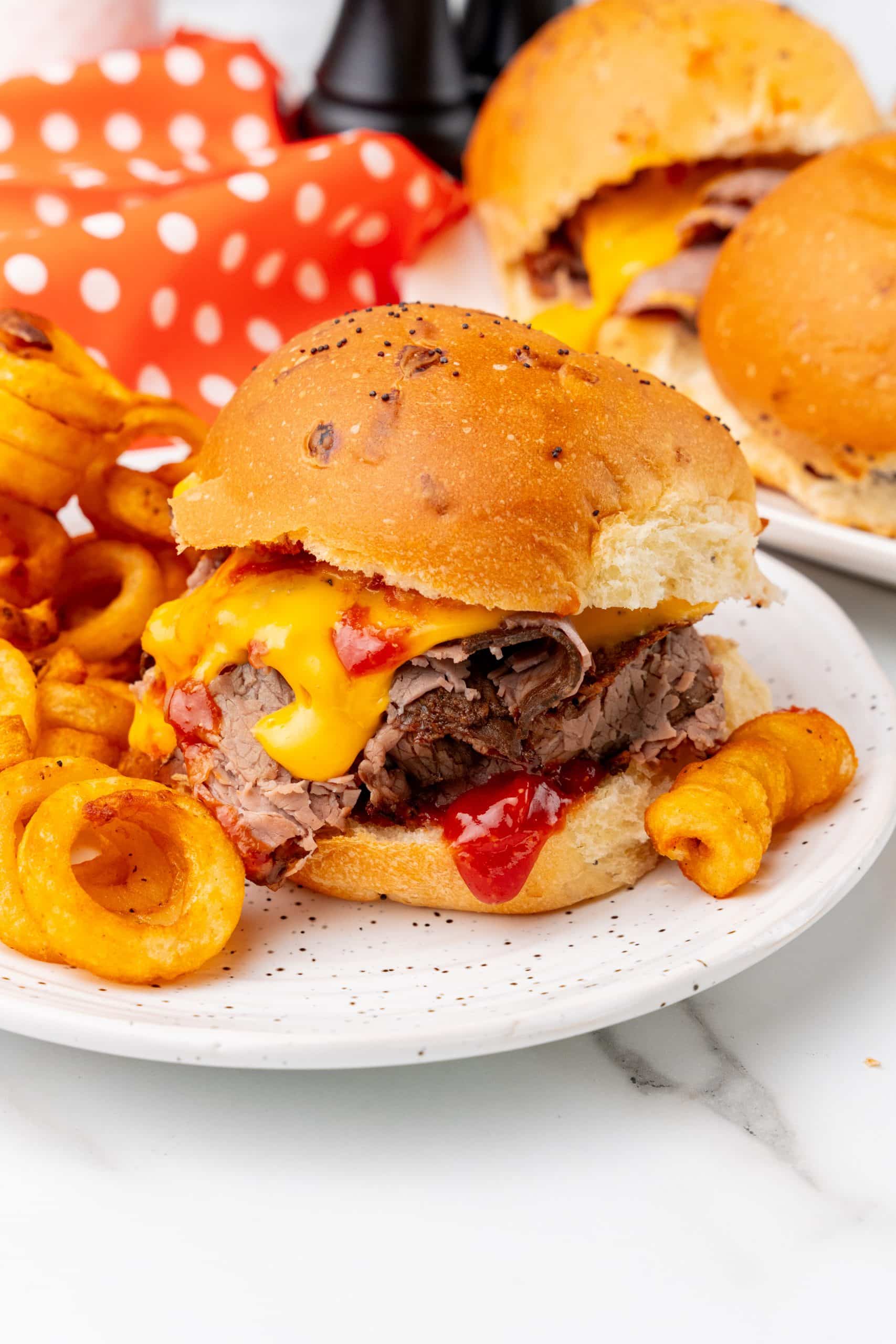 copycat arby's beef n' cheddars on white plates with curly fries on the side