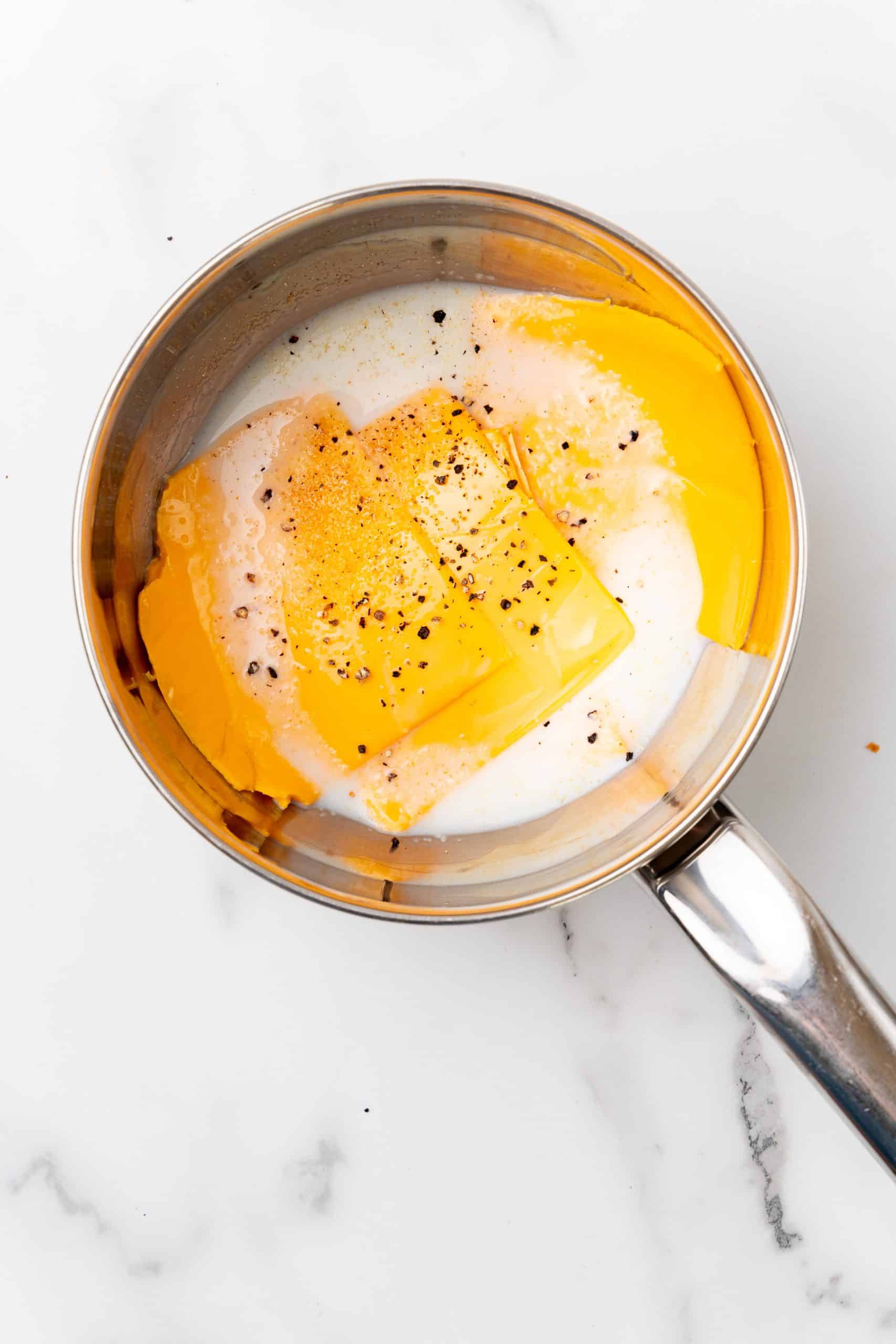 sliced cheese and milk in a small pot