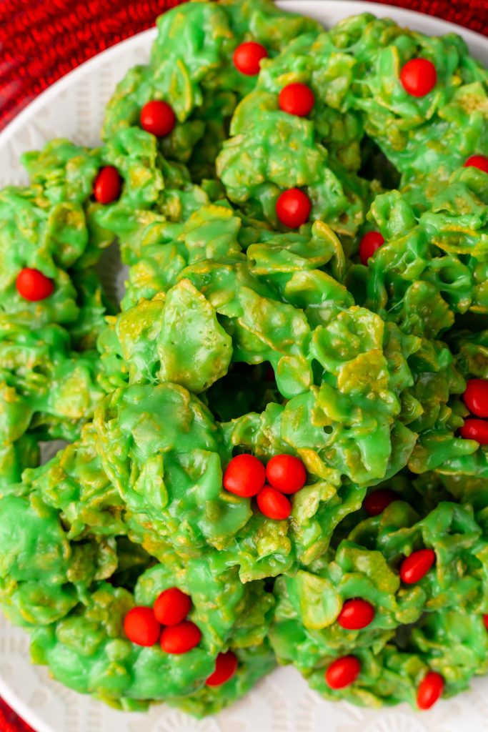 christmas wreath cookies piled on a white plate